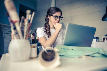 woman with concerned look in front of laptop
