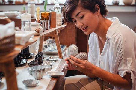 woman small business owner inspecting shop goods