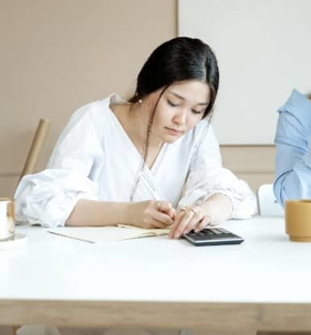 woman doing tax papers with calculator - sales tax helper