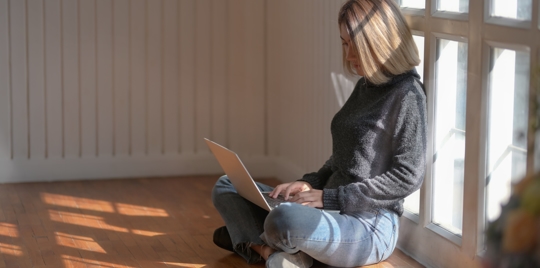 woman looking down at laptop doing research